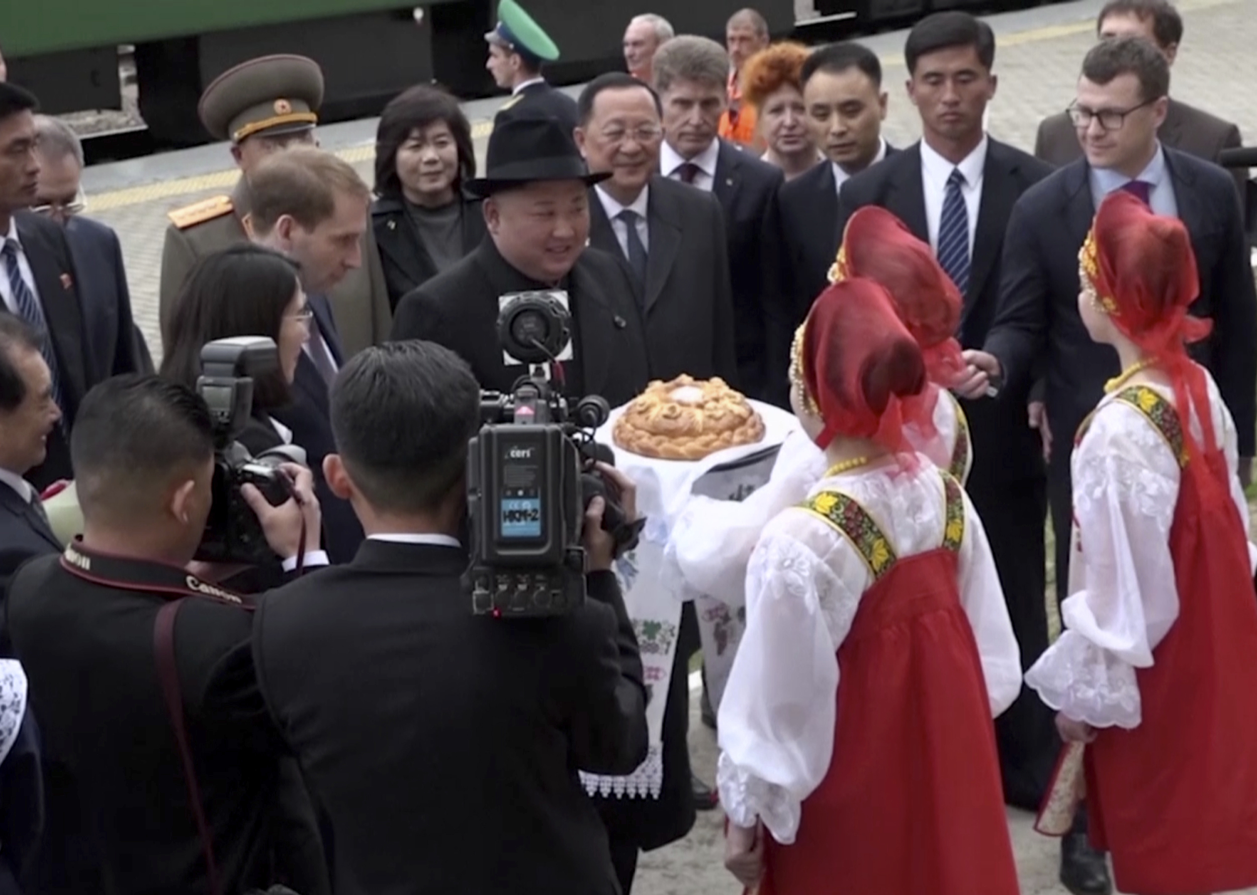 PHOTO: North Korean leader Kim Jong Un, center wearing a hat, is welcomed by girls clad in traditional Russian clothes upon arrival at Khasan train station in Primorye region, Russia, Wednesday, April 24, 2019.