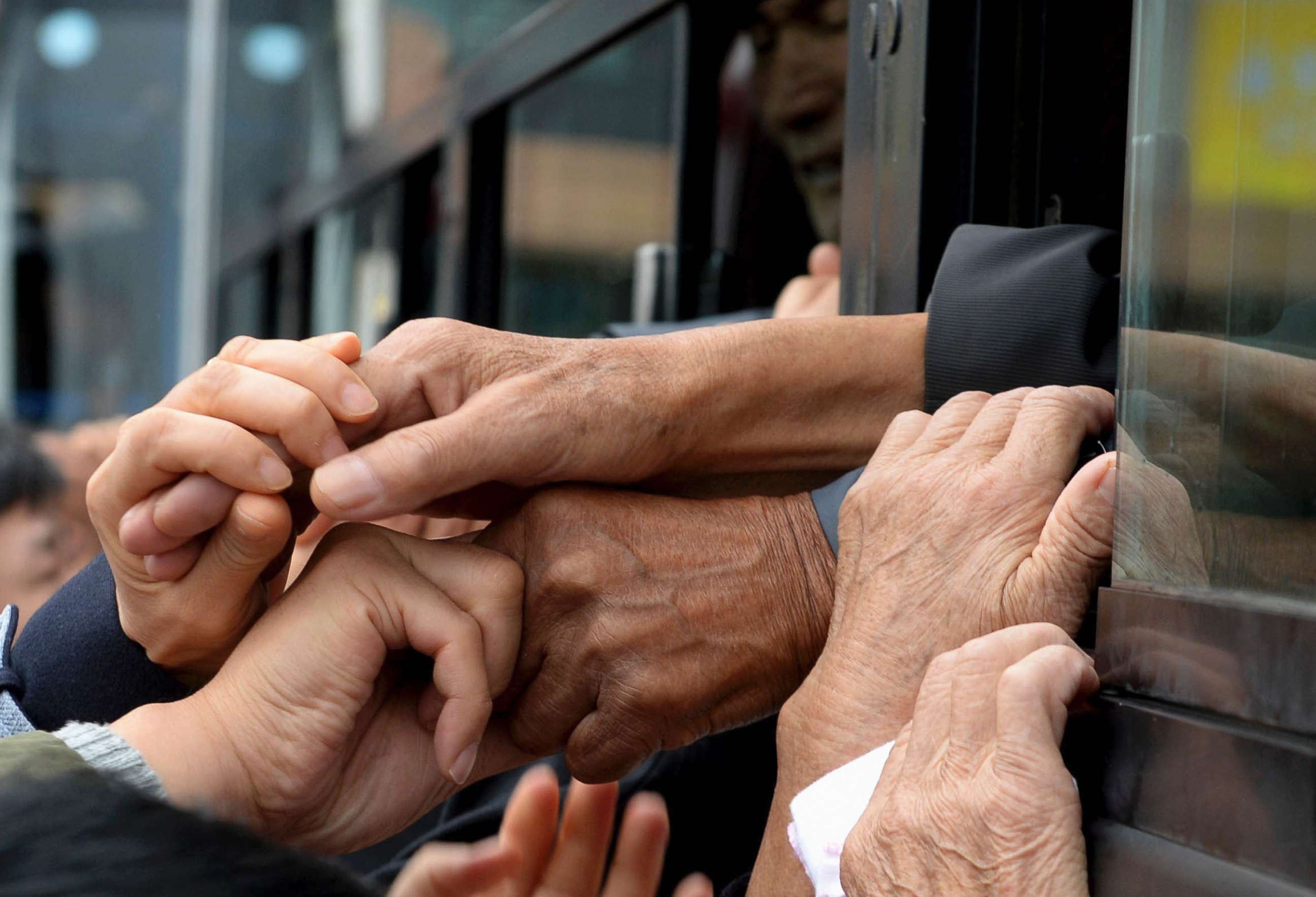 PHOTO: South Koreans and their North Korean relatives on a bus grip their hands each other to bid farewell after the Separated Family Reunion Meeting at Diamond Mountain resort in North Korea, Oct. 22, 2015.