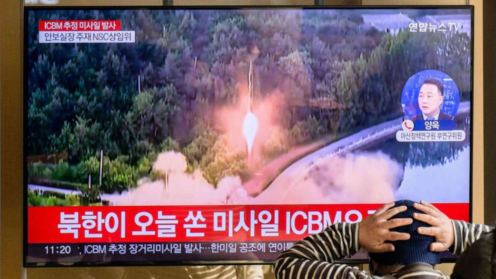 PHOTO: TOPSHOT - A man watches a television showing a news broadcast with file footage of a North Korean missile test, at a railway station in Seoul on November 18, 2022.