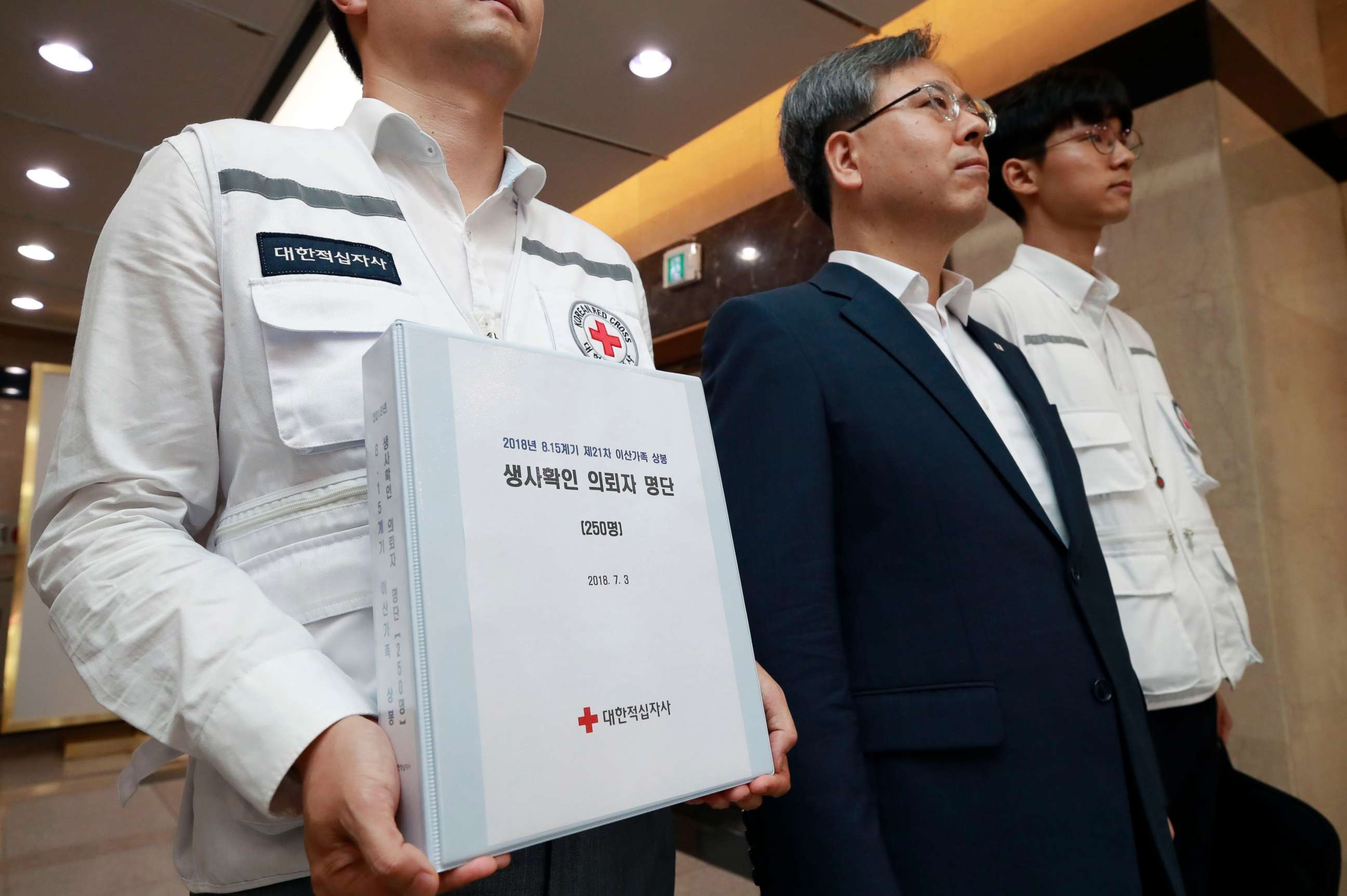 PHOTO: An official of the Korean Red Cross holds up documents containing a list of candidates for inter-Korean family reunions as a team of officials head out from their office in Seoul, South Korea, July 3, 2018. 