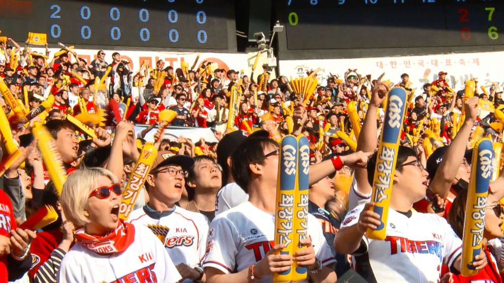 PHOTO: In Seoul, baseball fans wear team uniforms and wave balloon sticks in support of their team.