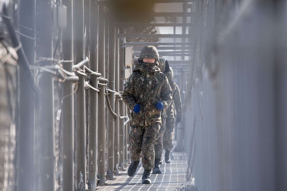 PHOTO: South Korean soldiers walk between a barbed wire fence on a beach near Goseong on South Korea's northeast coast, Feb. 11, 2018. Despite the thaw in ties with diplomatic visits during the 2018 Winter Olympic Games, little has changed near the DMZ.