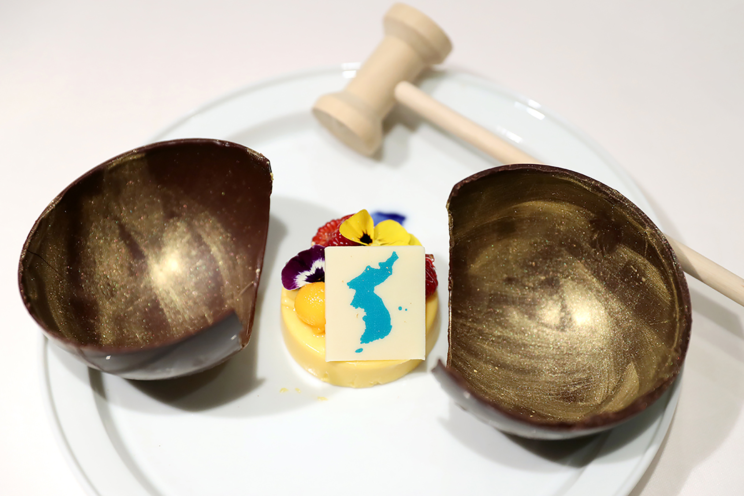 PHOTO: A mango mousse cake decorated with a garnish in the shape of a unified Korean peninsula, which will be served at the dinner of the upcoming inter-Korean summit. The wooden bowl will be broken by a hammer to symbolize the start of reconciliation.