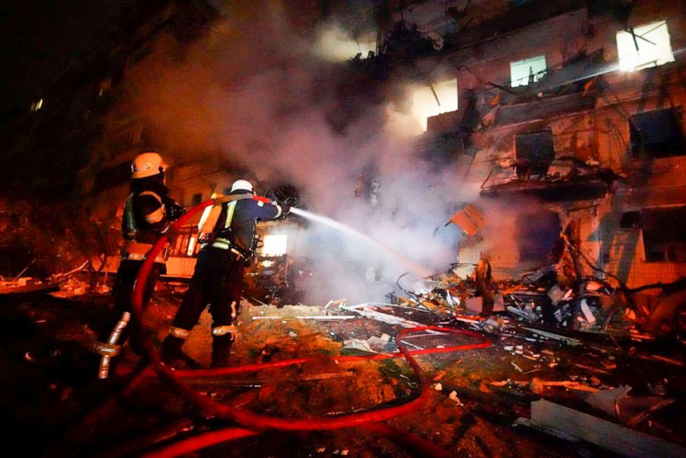 PHOTO: Firefighters hose down burning debris in front of a damaged building following a rocket attack on the city of Kyiv, Ukraine, Friday, Feb. 25, 2022.