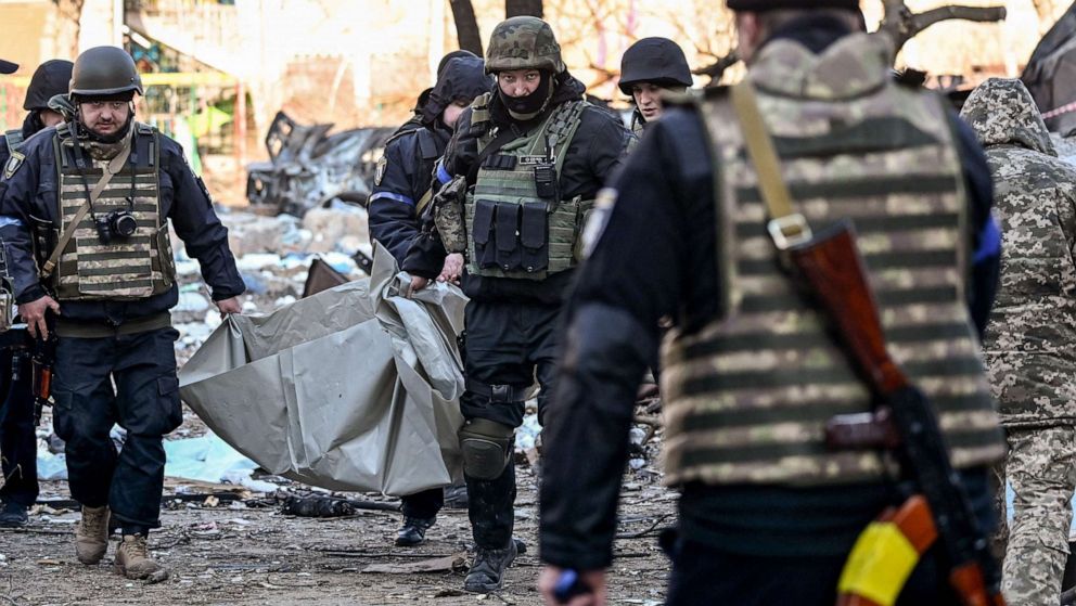 PHOTO: Ukrainian policemen carry a body away from a five-story residential building that partially collapsed after shelling in Kyiv, Ukraine on March 18, 2022.