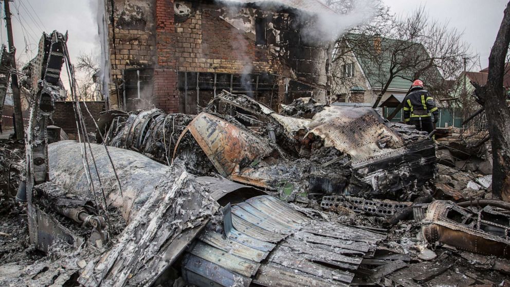 PHOTO: A Ukrainian firefighter walks between fragments of a downed aircraft seen in in Kyiv, Ukraine, Friday, Feb. 25, 2022.