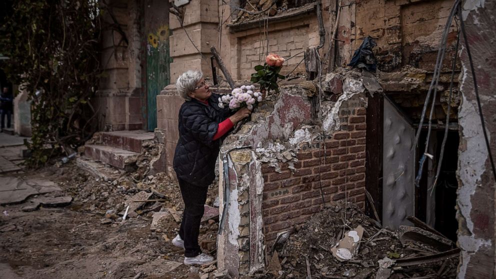 PHOTO: A woman arranges flowers outside a house where a couple was killed in a Russian drone strike two days beforehand, on Oct. 19, 2022 in Kyiv, Ukraine.