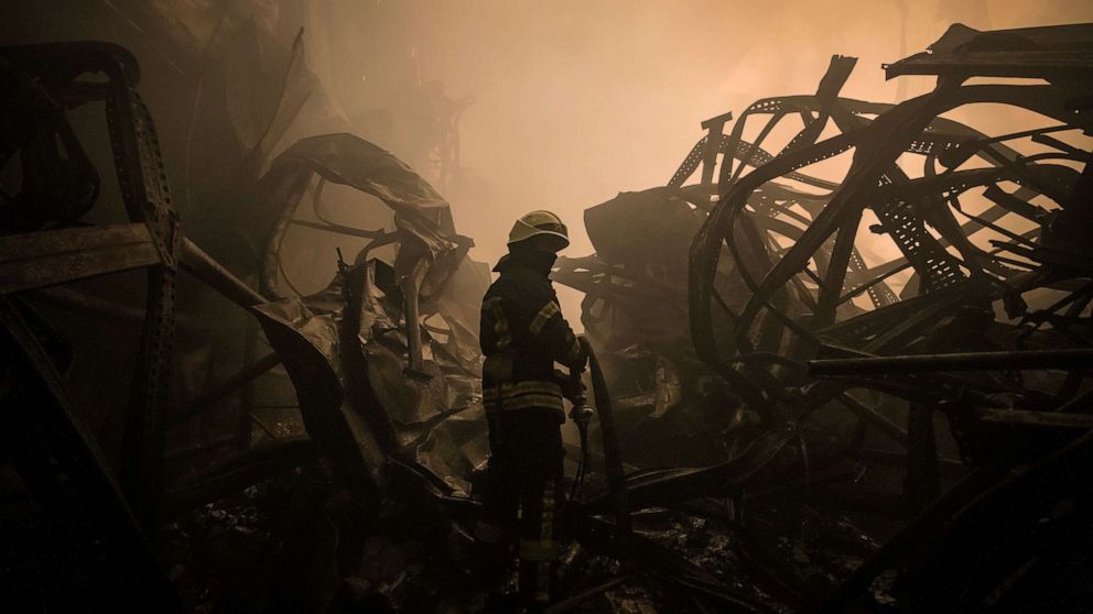 PHOTO: A Ukrainian firefighter drags a hose inside a large food products storage facility which was destroyed by an airstrike in the early morning hours on the outskirts of Kyiv, Ukraine, March 13, 2022.