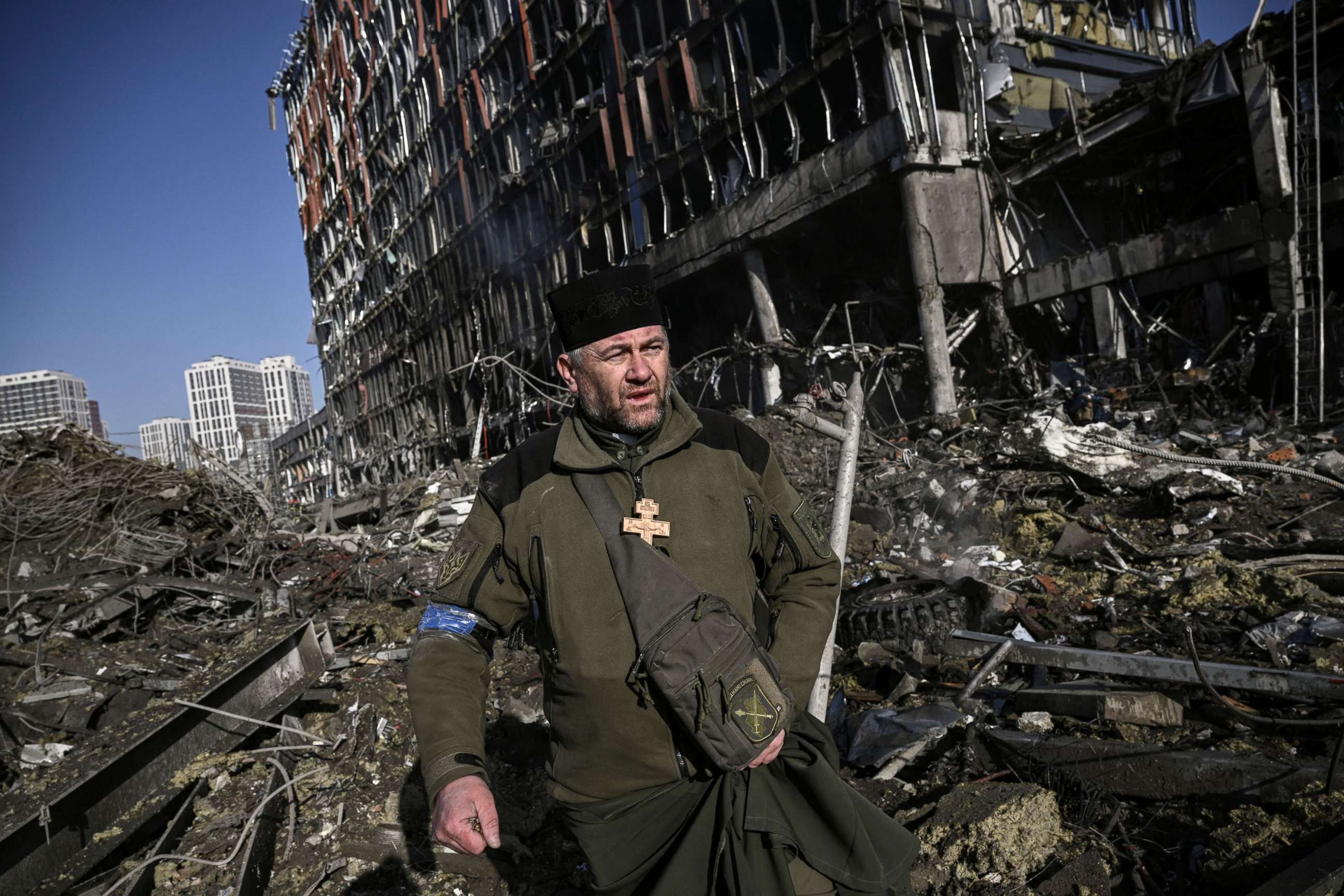 PHOTO: Ukraine army Chaplain Mikola Madenski walks through debris outside the destroyed Retroville shopping mall in a residential district, after a Russian attack on the Ukranian capital Kyiv on March 21, 2022.