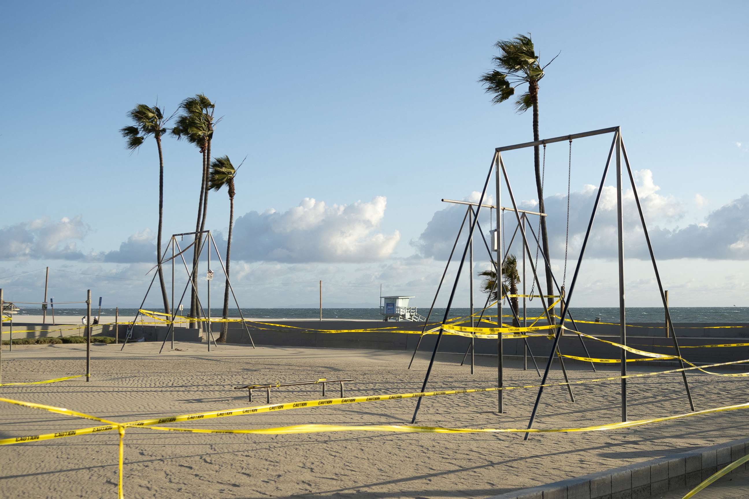 PHOTO: Yellow caution tape surrounds the Venice Beach boardwalk on March 26, 2020 in Los Angeles, closed due to the coronavirus pandemic.