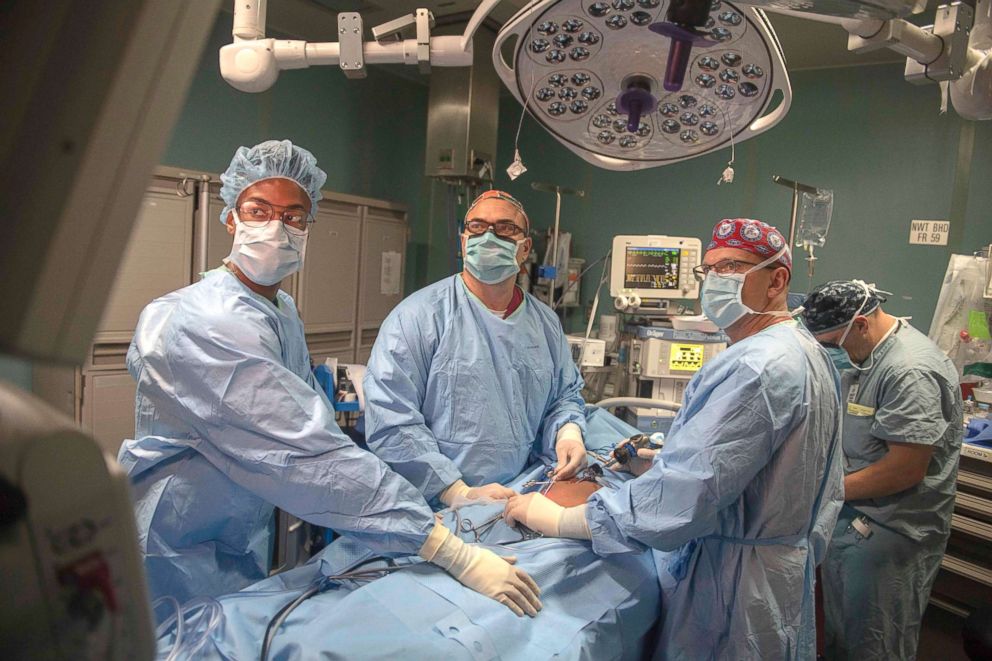 PHOTO: Medical personnel perform abdominal surgery on a patient to repair a hernia in the operating room aboard the hospital ship USNS Comfort.