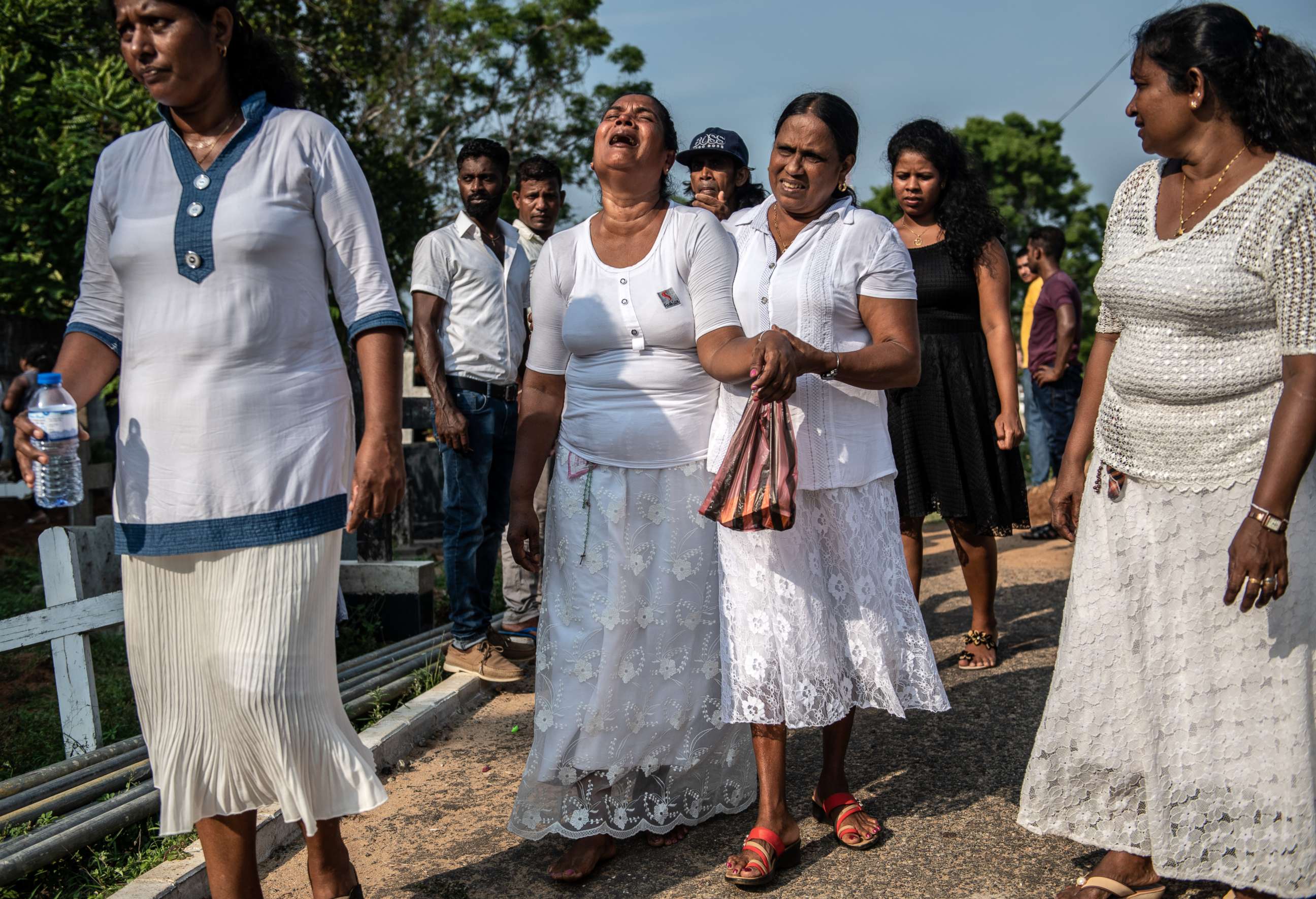 PHOTO: A crying woman is comforted as she leaves a funeral for a person killed in the Easter Sunday attack on St Sebastian's Church, April 23, 2019, in Negombo, Sri Lanka. 