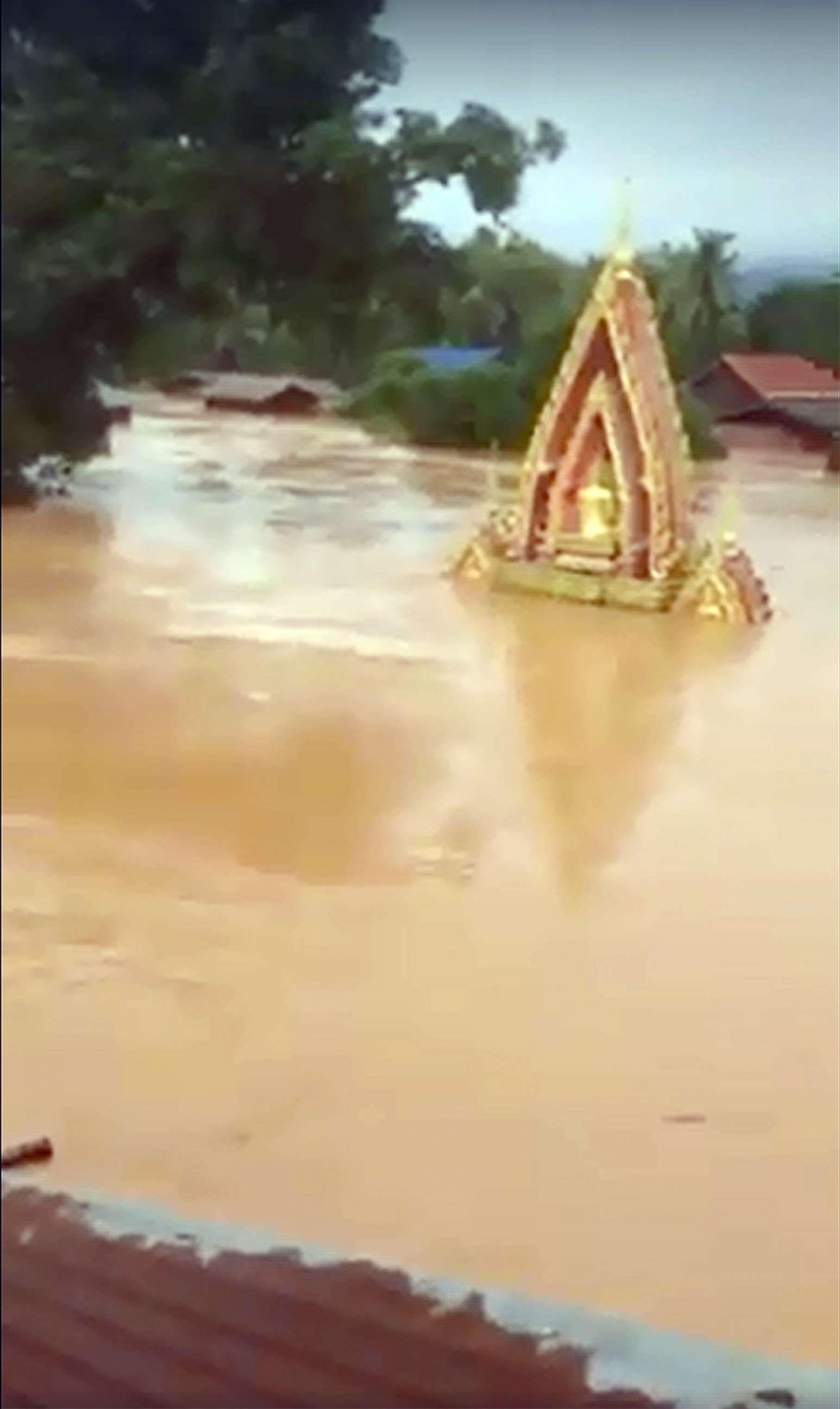 PHOTO: This screen grab taken on handout video footage from ABC Laos on July 24, 2018 shows various structures surrounded by floodwaters in Attapeu province after a dam collapsed the day before.