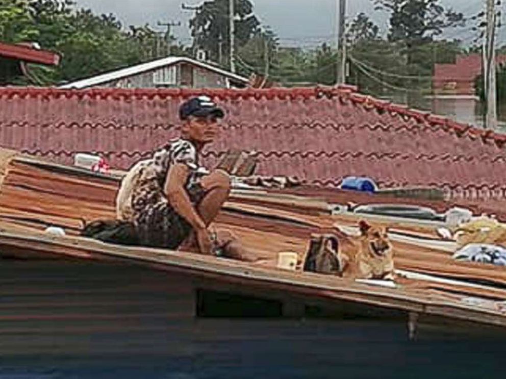 PHOTO: A villager takes refuge on a rooftop above flood waters from a collapsed dam in the Attapeu district of southeastern Laos, July 24, 2018.