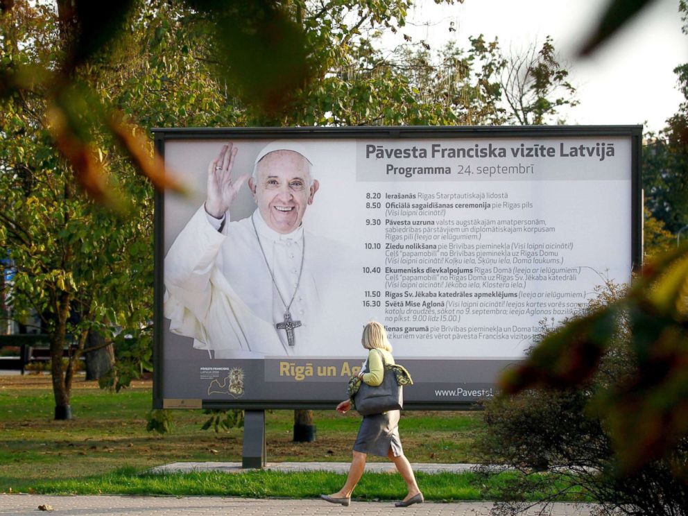 PHOTO: A woman walks next to a billboard advert of Pope Francis upcoming visit to Latvia, in Riga, Latvia, Sept. 20, 2018.