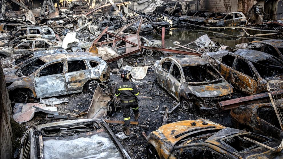 PHOTO: A firefighter walks through destroyed cars as a building burns after an Israeli airstrike, April 8, 2026 in Beirut, Lebanon. 