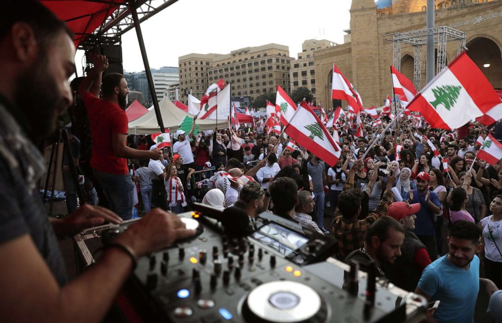 PHOTO: A DJ plays music as demonstrators wave national flags in the Martyrs' Square in Beirut, Lebanon, Oct. 27, 2019, during ongoing anti-government protests.