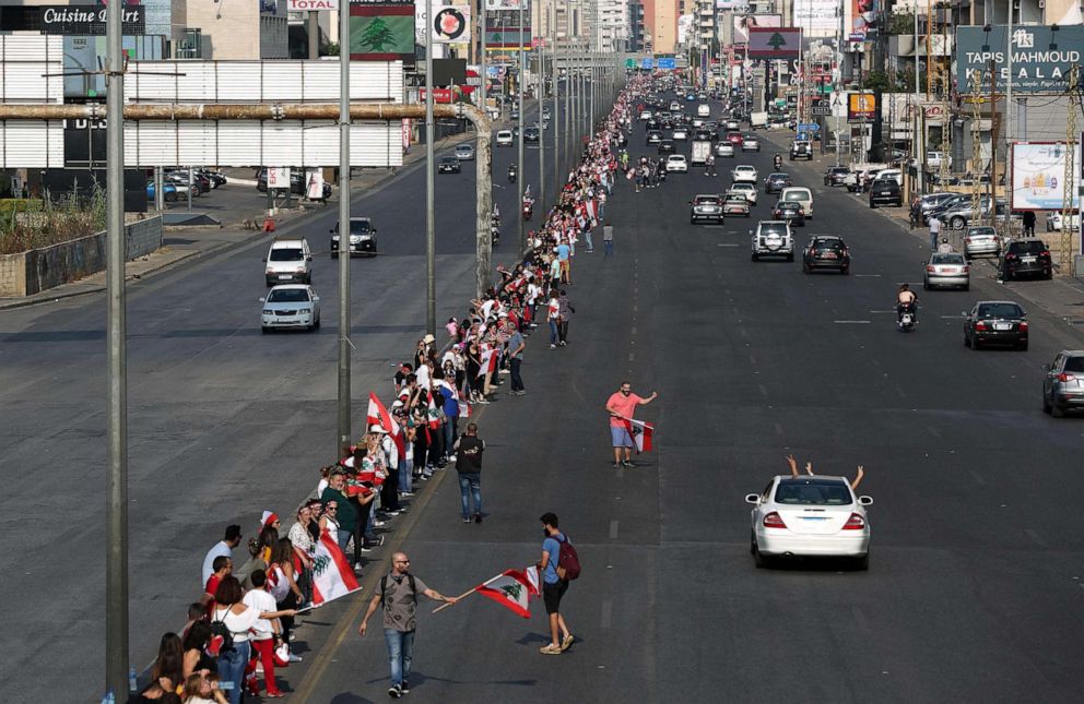 PHOTO: Lebanese protesters hold hands to form a human chain along the coast from north to south as a symbol of unity during ongoing anti-government demonstrations on Zalka highway north of Beirut on Oct. 27, 2019.