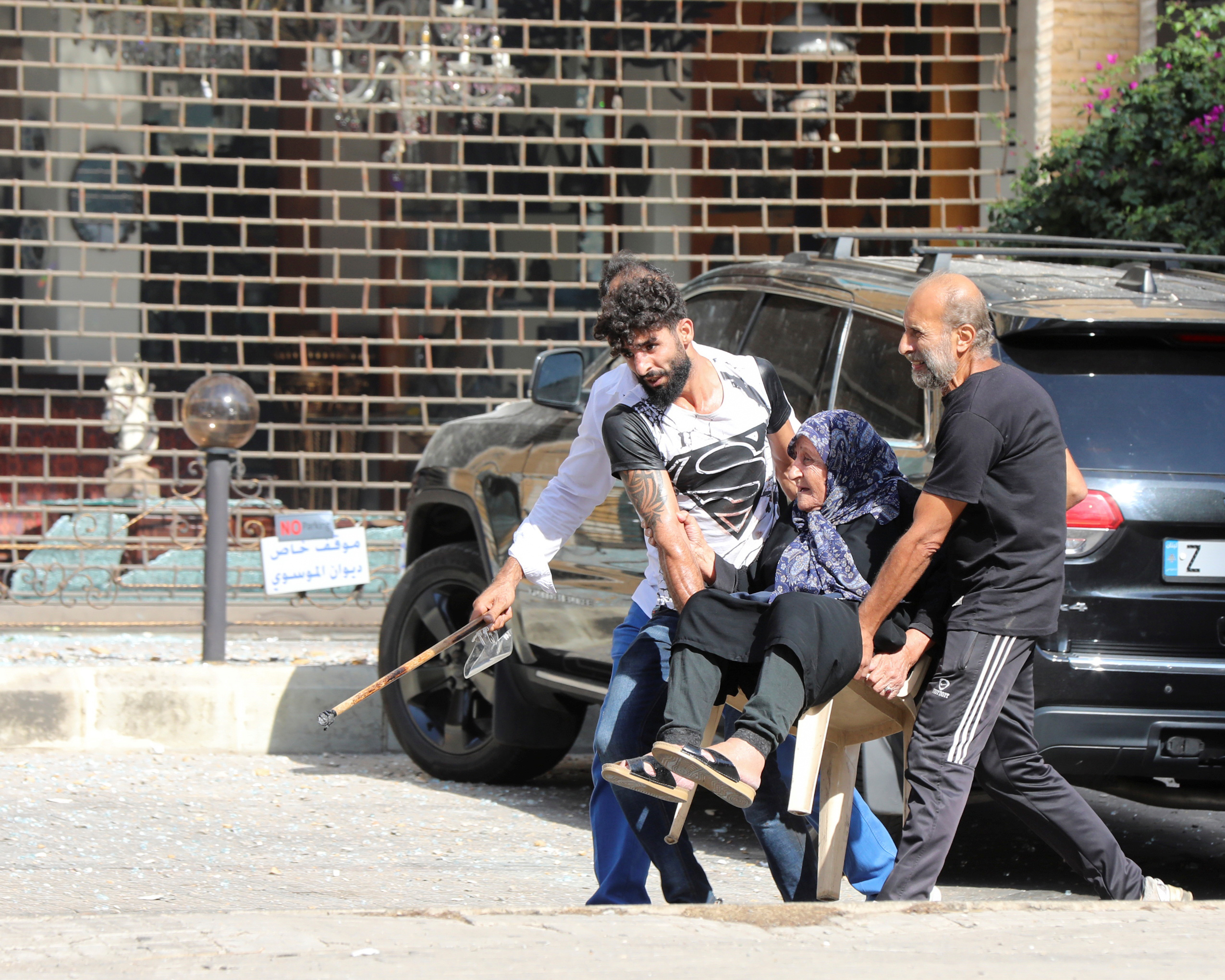 PHOTO: Men help evacuate an elderly woman after gunfire erupted, in Beirut, Oct. 14, 2021.