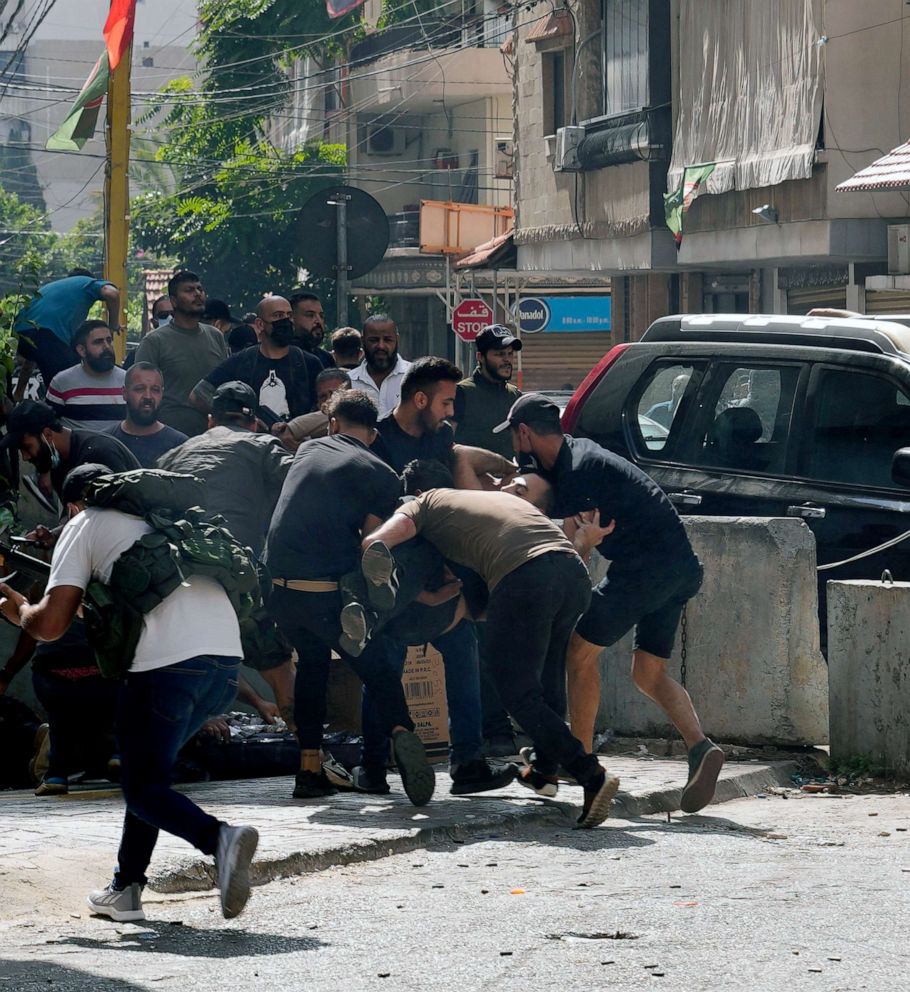 PHOTO: Supporters of a Shiite group allied with Hezbollah help an injured comrade during armed clashes that erupted during a protest in the southern Beirut suburb of Dahiyeh, Lebanon, Oct. 14, 2021. 