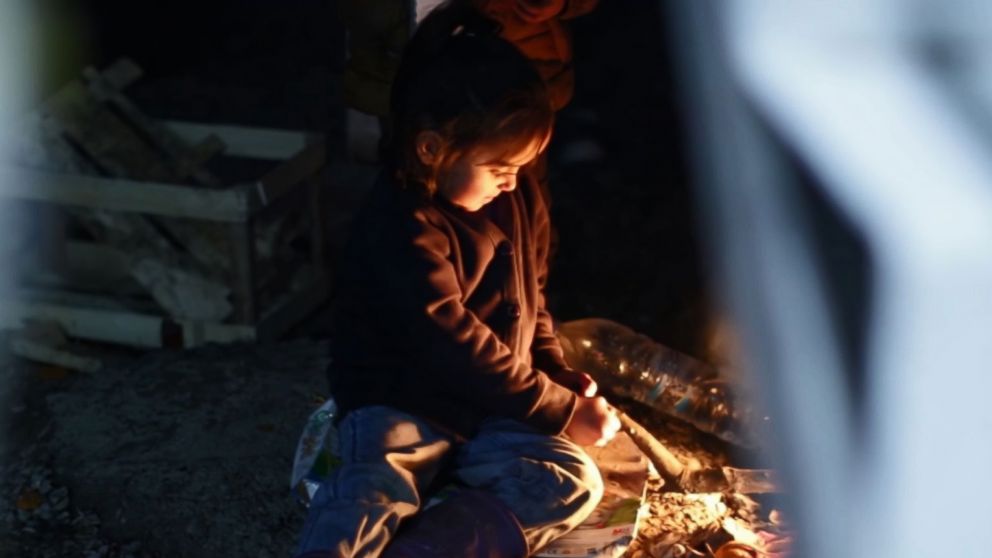 PHOTO: In Lesbos' Moria refugee camp, children gather around fires to keep warm.