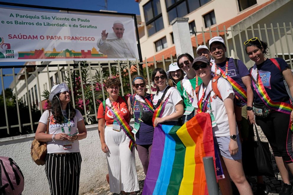 PHOTO: Victoria, left, from Spain, stands with representatives of Dignity USA, a group of LGBTQ+ Catholics after Pope Francis visited, in the Serafina neighbourhood of Lisbon, Friday, Aug. 4, 2023.
