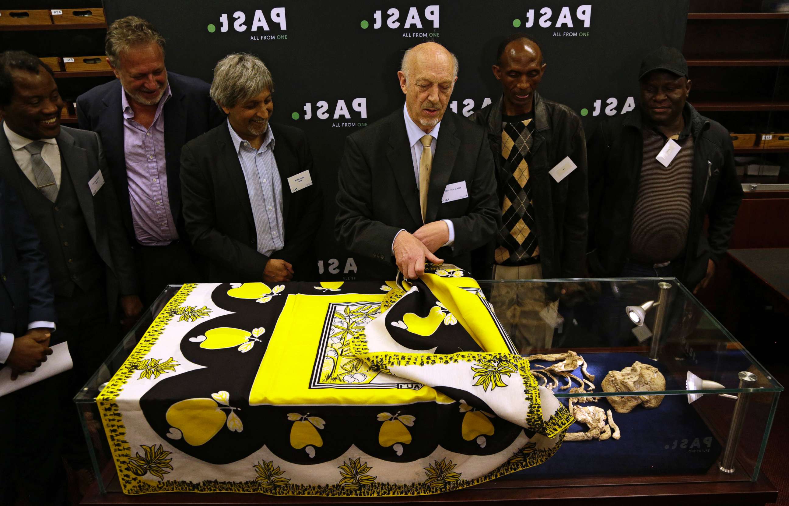 PHOTO: Ron Clarke, a professor from the Evolutionary Studies Institute at the University of the Witwatersrand, center, unveils the virtually complete Australopithecus fossil "Little Foot" in Johannesburg, South Africa, Dec. 6, 2017. 