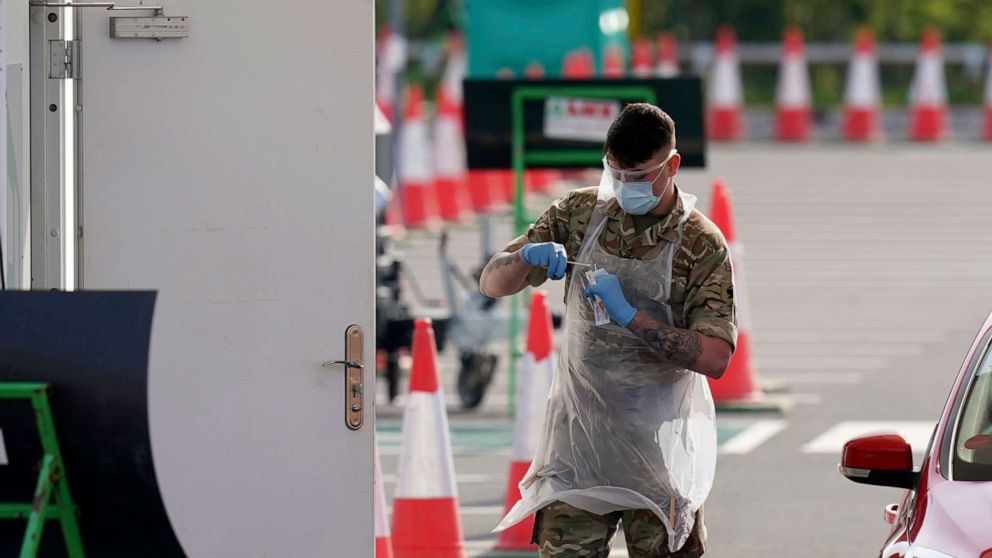 PHOTO: A soldier walks back to a hut after testing a NHS (National Health Service) worker for Covid-19 at a drive-through testing centre, in Manchester, northern England, April 9, 2020.