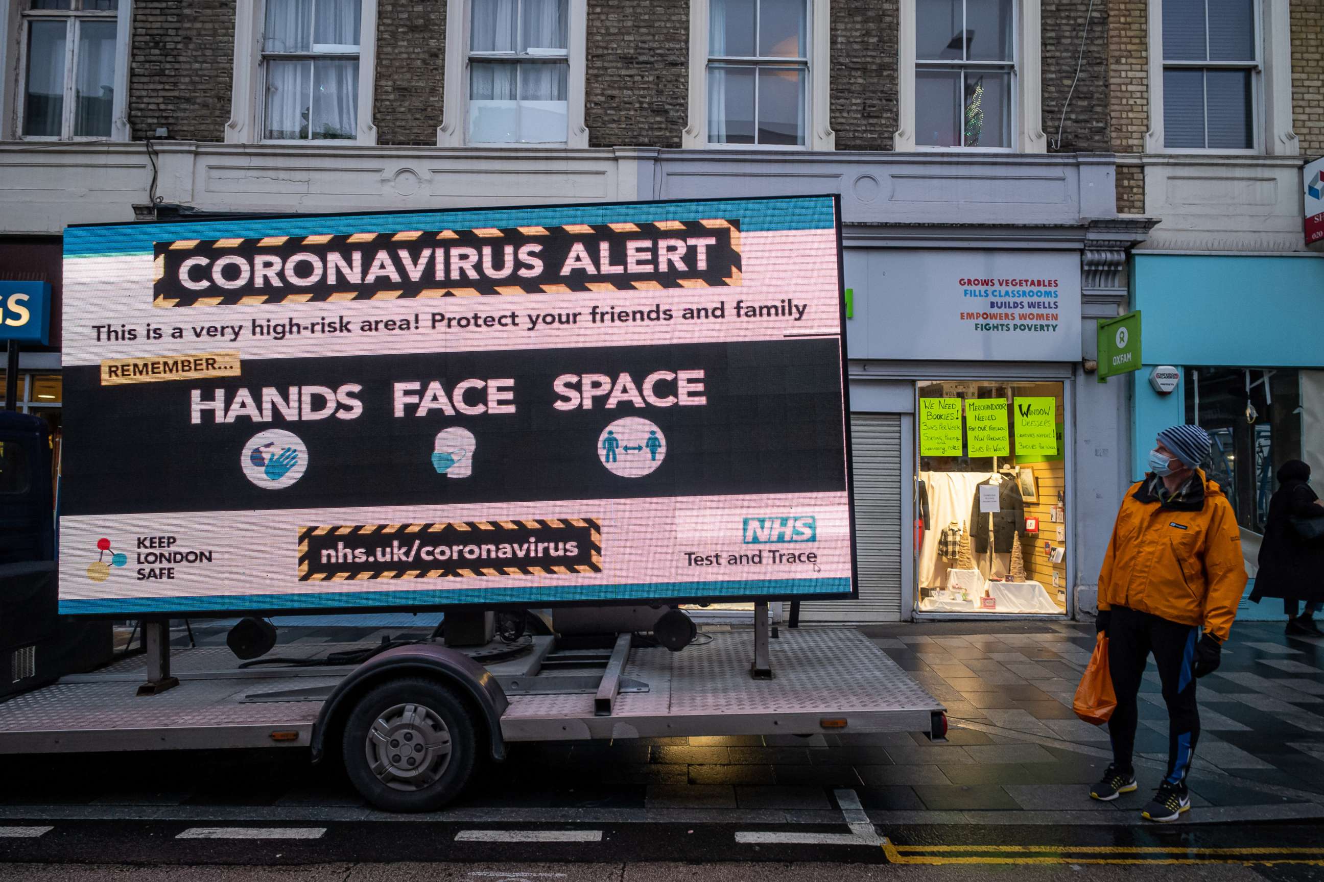 PHOTO: A man looks at a huge coronavirus alert sign warning members of the public to be vigilant in Putney, South West London, on Dec. 23, 2020.
