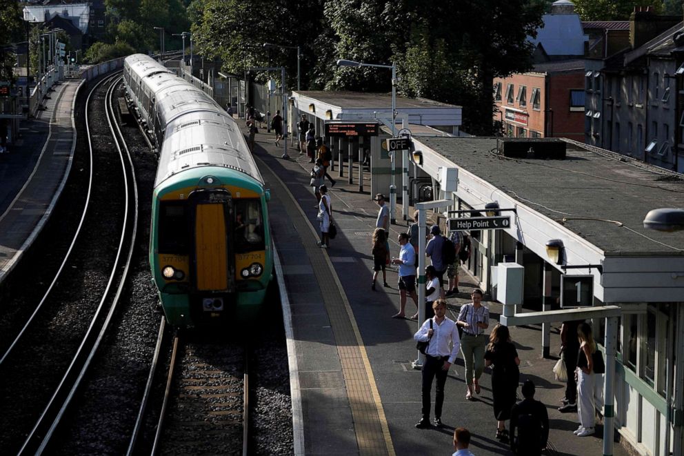 PHOTO: Commuters wait for their train on a platform at West Norwood station in south London, on July 18, 2022, amid disruption warnings over extreme heat.