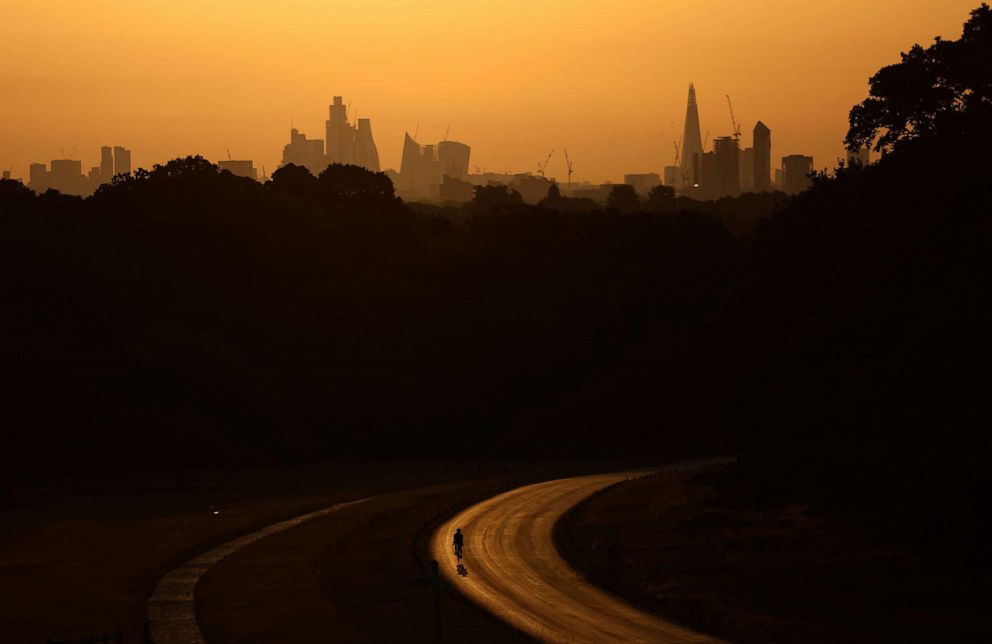 PHOTO: A cyclist rides through Richmond Park at sunrise during a heatwave in London, on July 18, 2022.