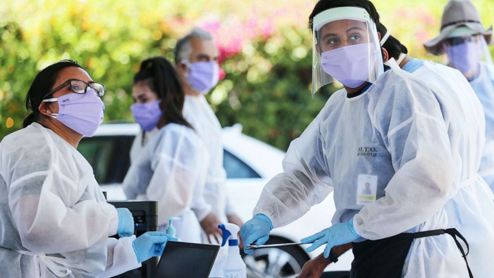 PHOTO: Healthcare workers facilitate tests at a drive-in COVID-19 testing center at M.T.O. Shahmaghsoudi School of Islamic Sufism on Aug. 11, 2020, in Los Angeles.