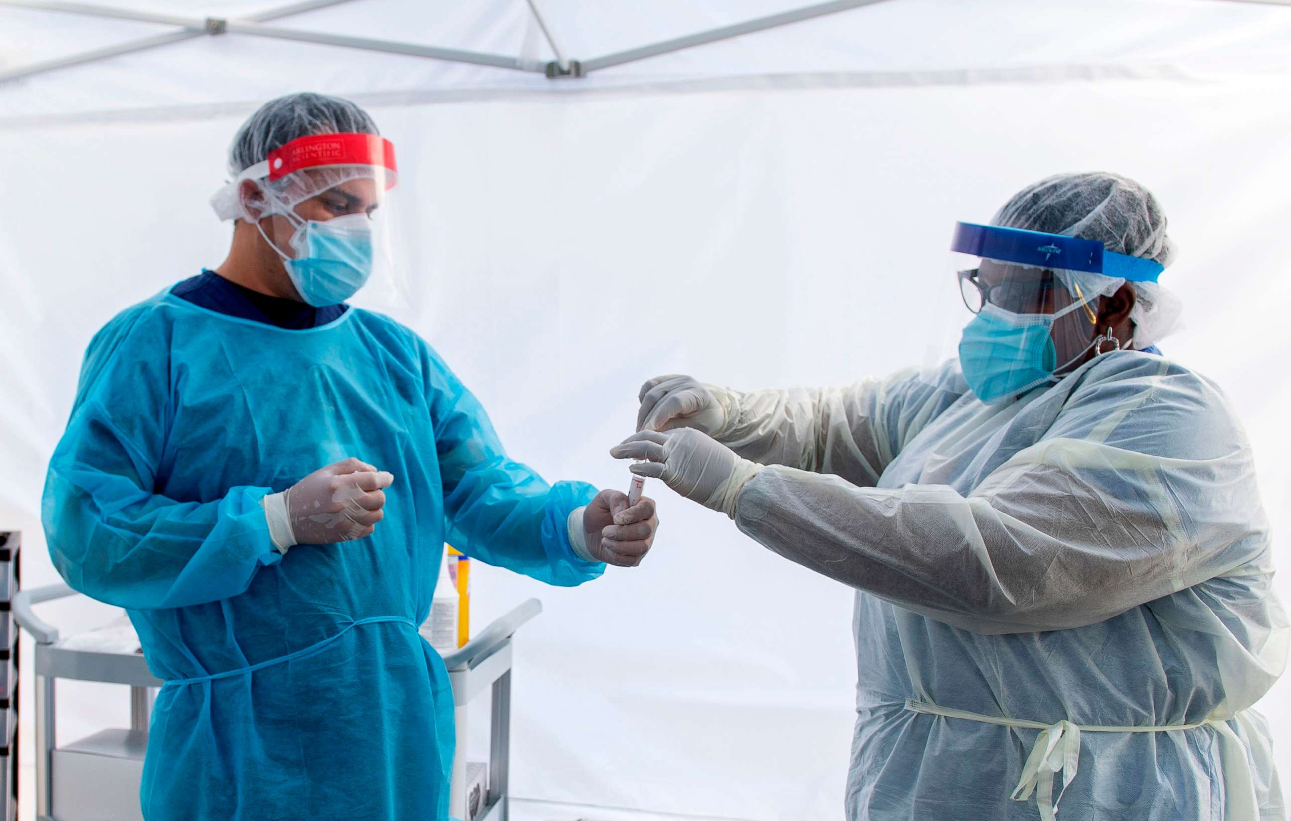 PHOTO: A health worker puts a nasal swab sample into a tube in a tent at a COVID-19 testing site at St. John's Well Child and Family Center, amid the COVID-19 pandemic, July 24, 2020, in Los Angeles.