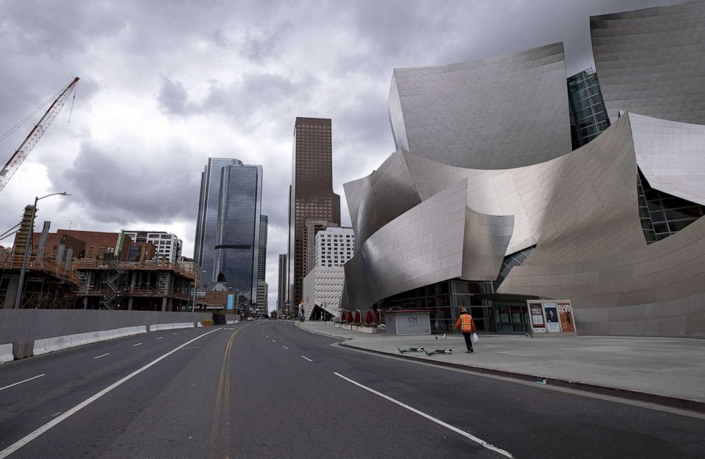 PHOTO: A man walks on an empty street past the closed Walt Disney Concert Hall amid the coronavirus pandemic in Los Angeles, March 16, 2020.