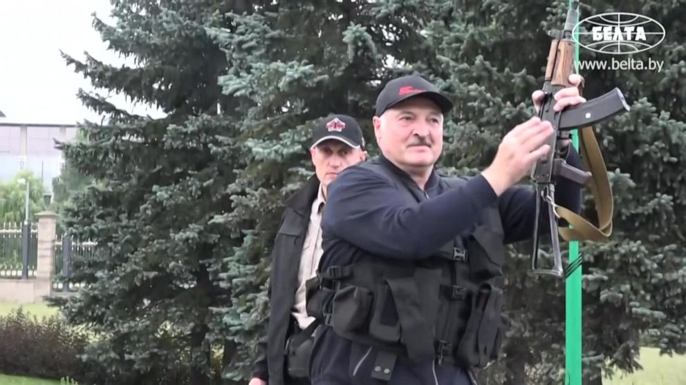 PHOTO: This grab taken from a video released by Belarus state agency "Belta" shows President Alexander Lukashenko holding an automatic rifle and wearing body armour as he arrives, on August 23, 2020, at his residence in Minsk. 