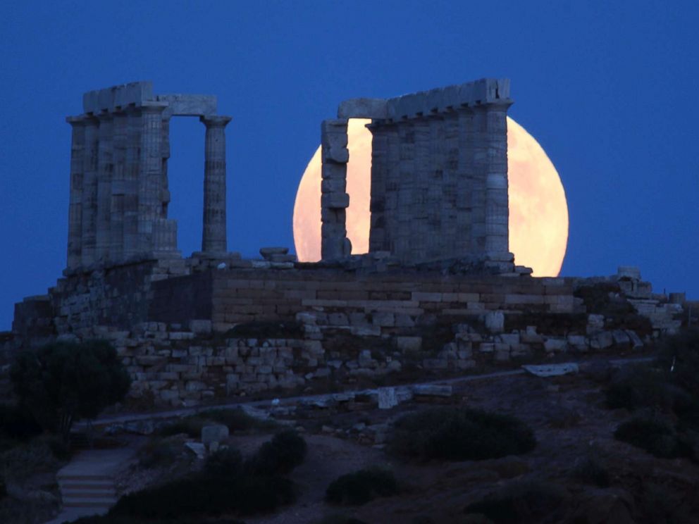 PHOTO: A full moon rises behind the ancient temple of Poseidon in Cape Sounio, south of Athens, July 27, 2018.