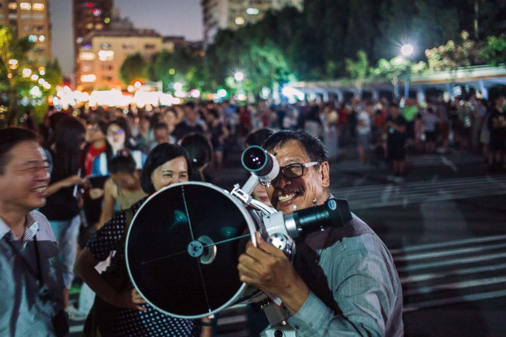 PHOTO: People set up telescopes to witness a rare lunar eclipse, July 27, 2018 in Taipei, Taiwan.