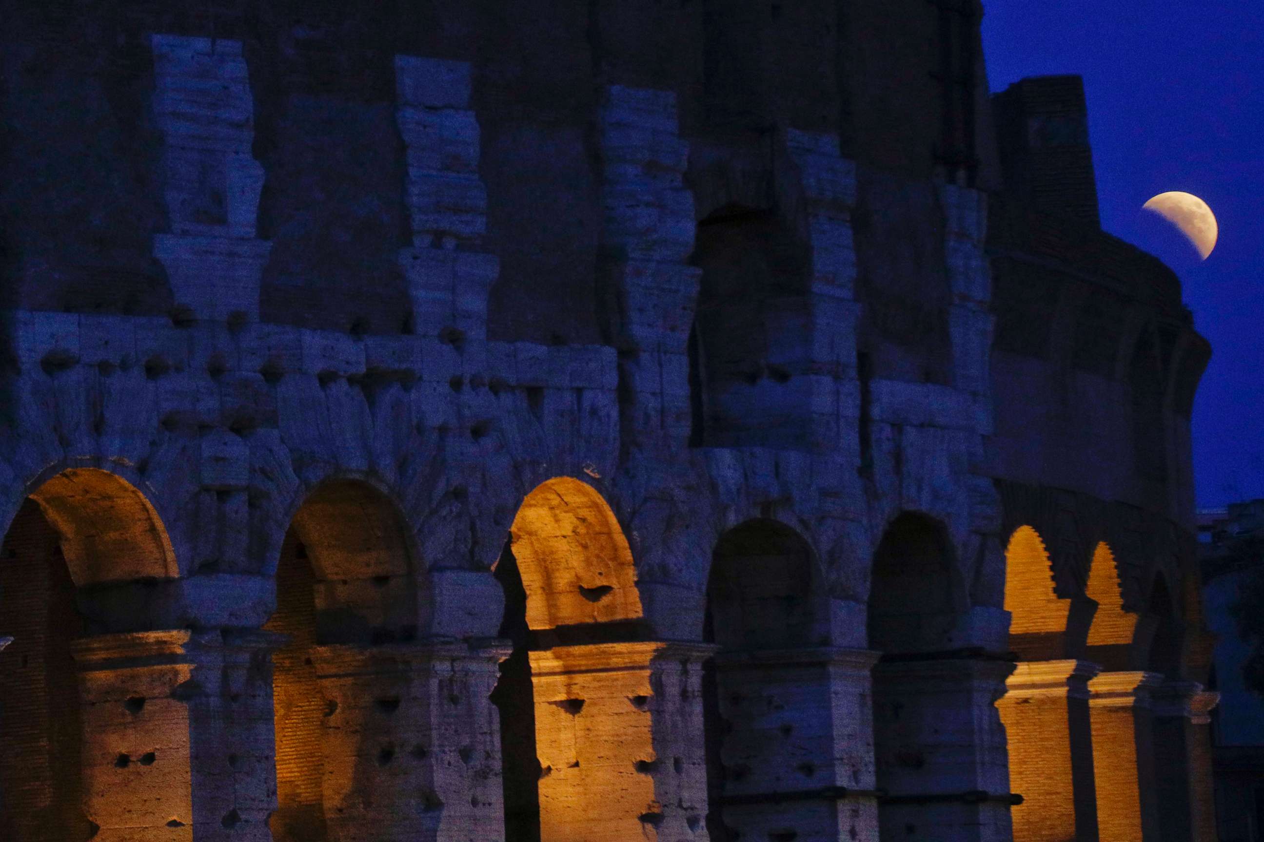 PHOTO: The moon rises over the Colosseum during a complete lunar eclipse, in Rome, July 27, 2018.