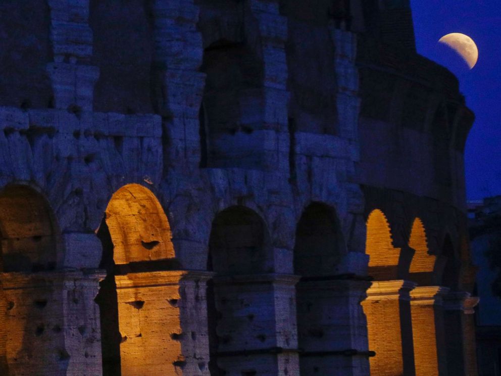 PHOTO: The moon rises over the Colosseum during a complete lunar eclipse, in Rome, July 27, 2018.