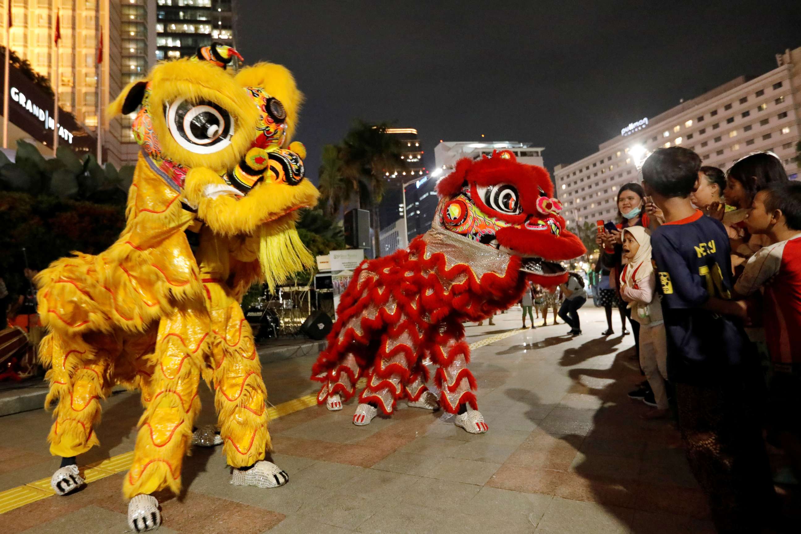 PHOTO: A girl reacts as she watches the lion dance show on the sidewalk during Chinese Lunar New Year celebrations in Jakarta, Indonesia, Jan. 24, 2020.