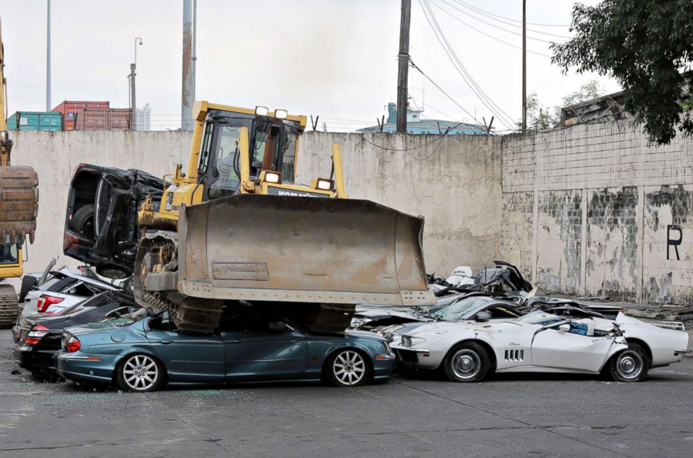 PHOTO: A bulldozer rolls over seized luxury cars during the ceremonial destruction at the Bureau of Customs in Manila, Feb. 6, 2018.