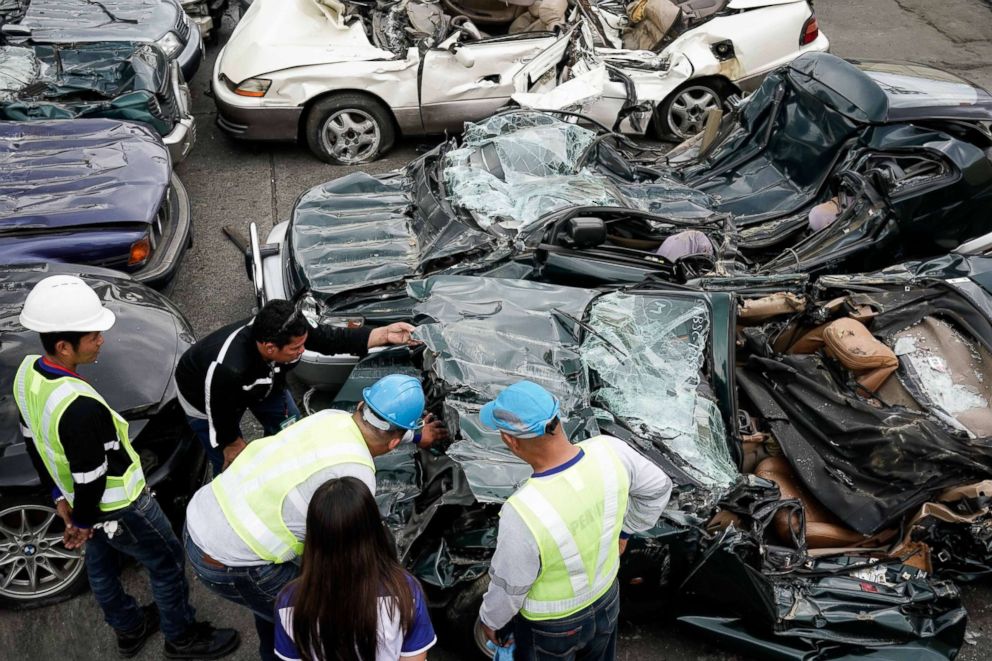 PHOTO: Bureau of Customs officials inspect destroyed smuggled luxury cars at the Bureau of Customs in Manila, February 6, 2018. 