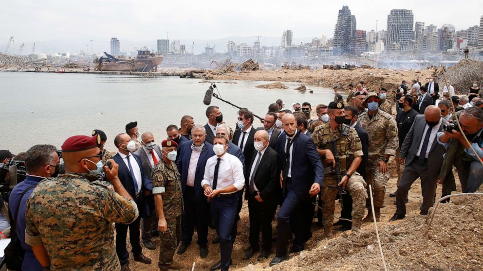 PHOTO: French President Emmanuel Macron, center, visits the devastated site of the explosions at the port of Beirut, Aug.6, 2020.