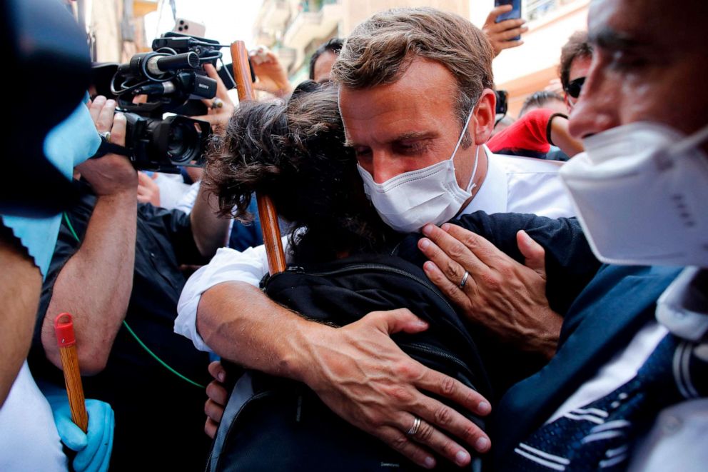 PHOTO: French President Emmanuel Macron hugs a resident as he visits a street devastated by the recent explosions in Beirut on Aug. 6, 2020.