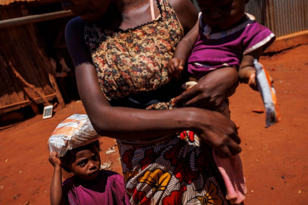 PHOTO: A mother and her two children leave a children's malnutrition post run by the World Food Program, holding sachets of Plumpy, in Anjeky Beanatara, Madagascar, Feb. 11, 2022.
