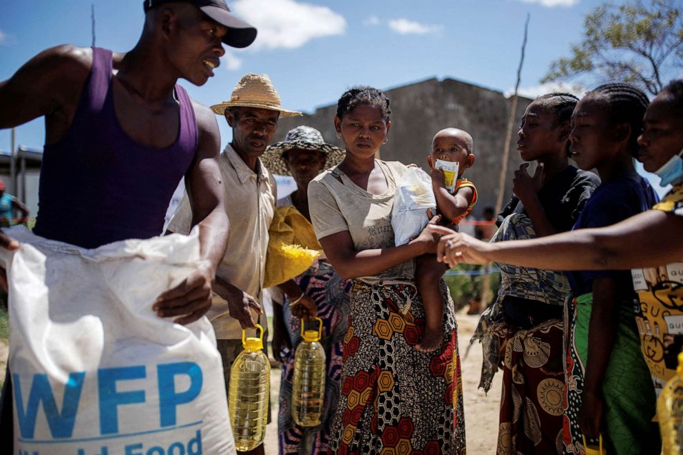 PHOTO: Masy Modestine, 20, holds her son Lahimaro, 2, while waiting to receive goods at a food distribution post run by the World Food Program in the Antanimora commune, Madagascar, Feb. 12, 2022.