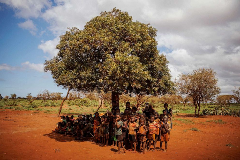 PHOTO: Children and their mothers sit under a tree as they wait to be examined at a children's malnutrition post run by the World Food Program in Anjeky Beanatara, Madagascar, Feb. 11, 2022.