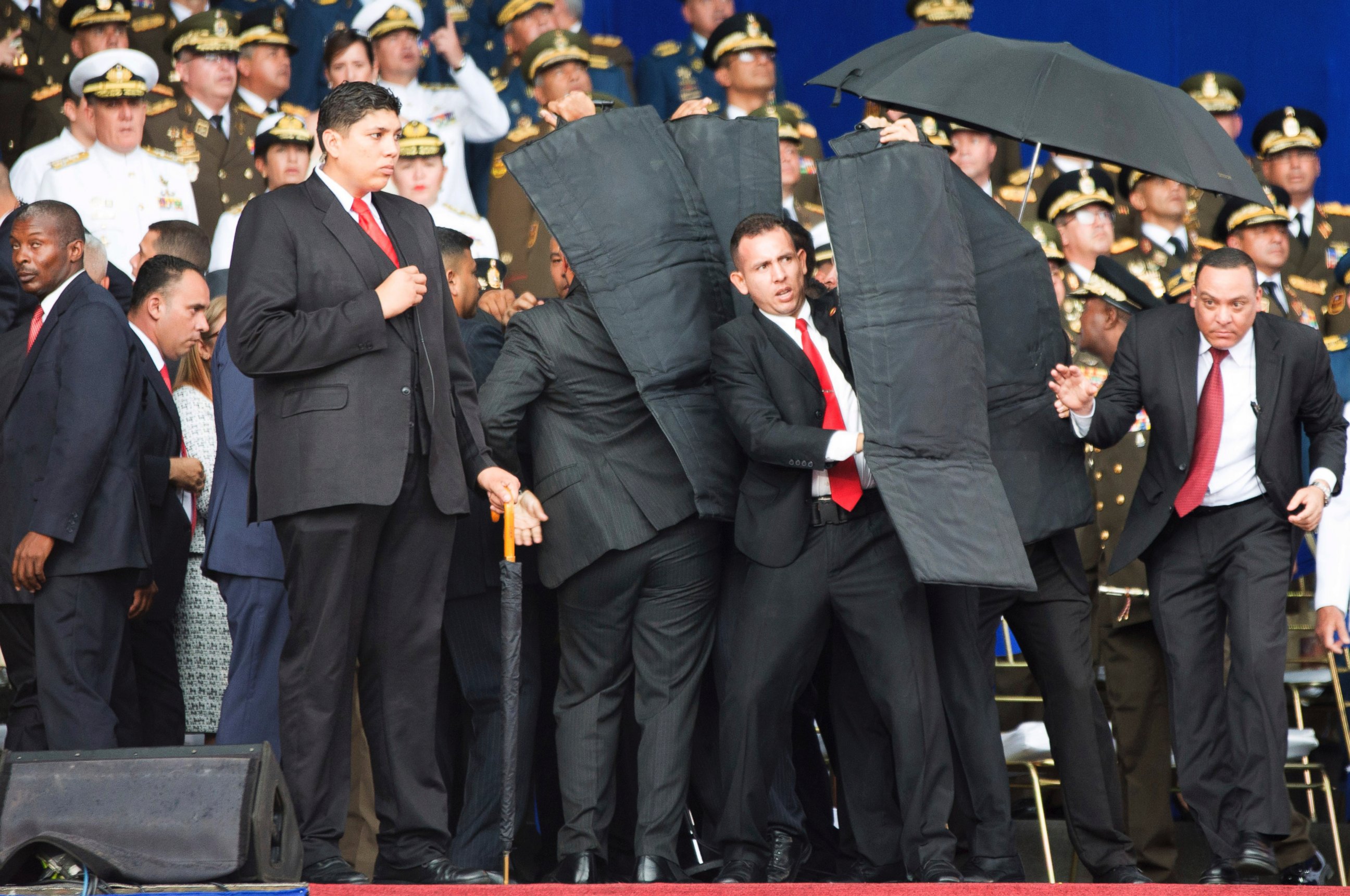 In this photo released by China's Xinhua News Agency, security personnel surround Venezuela's President Nicolas Maduro during an incident as he was giving a speech in Caracas, Venezuela, Saturday, Aug. 4, 2018.