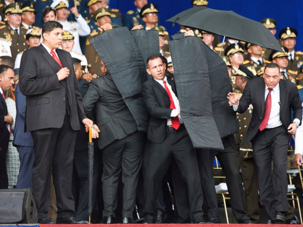 In this photo released by Chinas Xinhua News Agency, security personnel surround Venezuelas President Nicolas Maduro during an incident as he was giving a speech in Caracas, Venezuela, Saturday, Aug. 4, 2018.