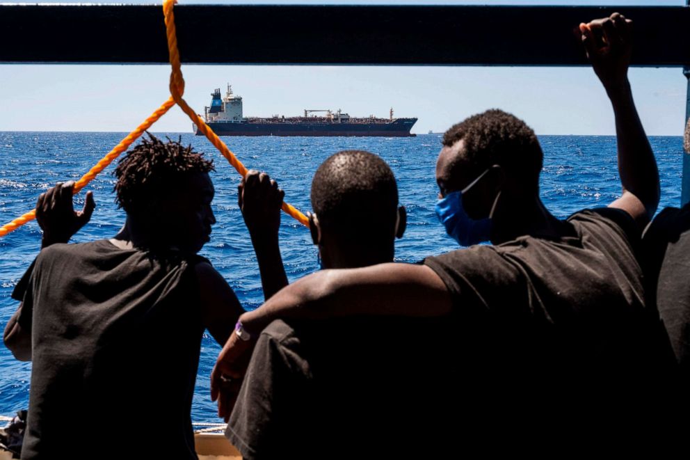 PHOTO: Migrants onboard the Sea-Watch 4 civil sea rescue ship watch towards the oil tanker Maersk Etienne off the coast of Malta on Aug. 27, 2020.